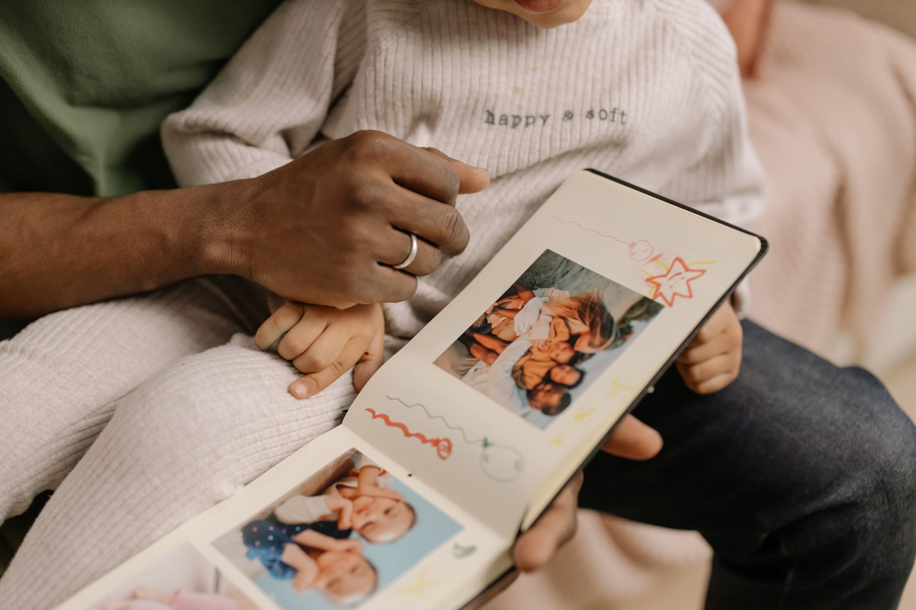 A father and child share a touching moment revisiting cherished family memories in a photo album.